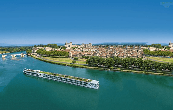 The Scenic Sapphire ship cruising past the historic city of Avignon on the Rhone River, under a clear blue sky.