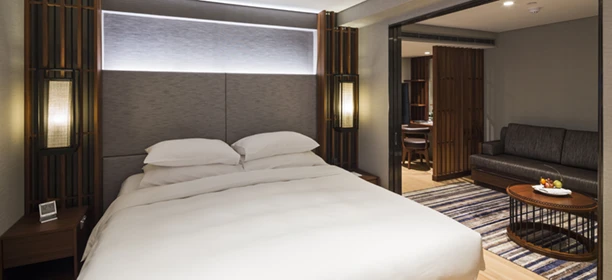 Queen size Scenic Slumber Bed and separate lounge area in the Grand Deluxe Suite on the Scenic Spirit ship.