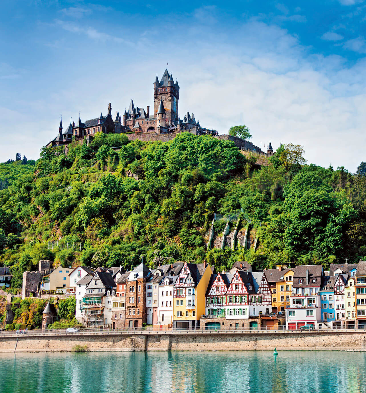 Colourful houses and Reichsburg Castle on the hill next to the Moselle River in Cochem, Germany