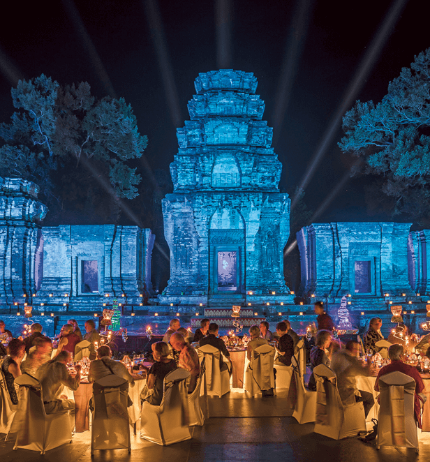 Guests enjoying an exclusive illuminated dinner event at an ancient temple in Southeast Asia with Scenic Cruises