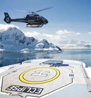 The helicopter aboard Scenic Eclipse hovers above a vast expanse of ice, showcasing the stark beauty of the frozen landscape below.